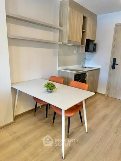 Modern kitchen with sleek design, featuring compact dining area and stylish cabinetry.