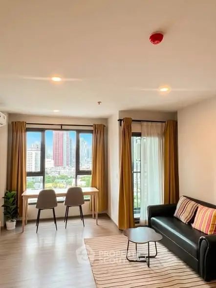 Modern living room with city view, stylish furniture, and large windows in a high-rise apartment.