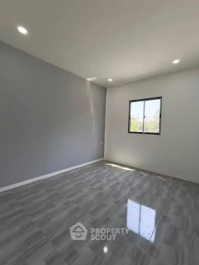 Spacious empty room with modern tiled flooring and large window