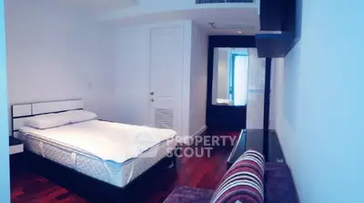 Spacious bedroom with modern decor and hardwood floors in a luxury apartment.