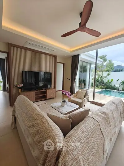 Luxurious living room with pool view, modern decor, and cozy seating area.