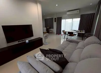 Spacious living room with modern sofa and large TV, perfect for relaxation and entertainment.