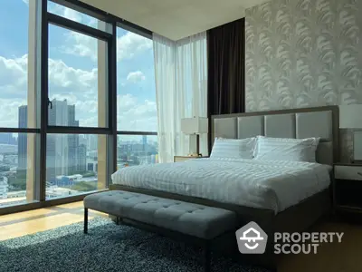 Luxurious bedroom with floor-to-ceiling windows offering panoramic city views, complemented by a plush king-sized bed and elegant decor.