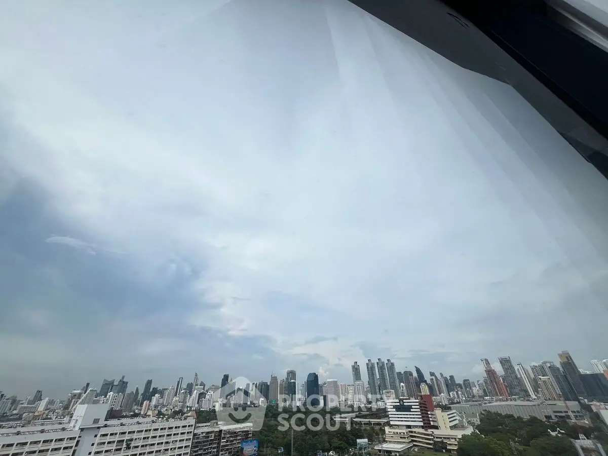 Stunning panoramic city skyline view from high-rise apartment window.