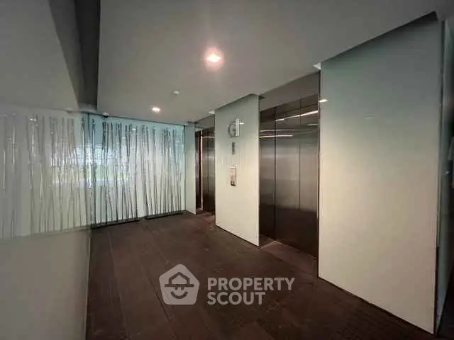 Modern elevator lobby with sleek design and ambient lighting in a contemporary building.