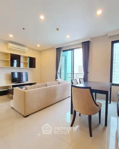 Spacious modern living room with large windows and elegant furniture in a high-rise apartment.