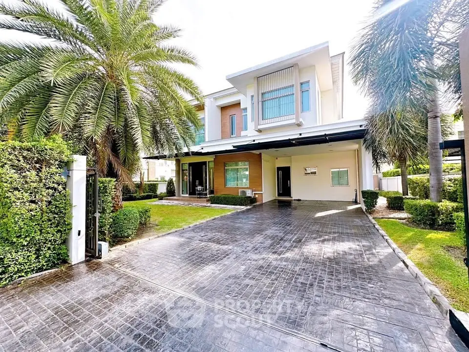 Luxurious modern house with spacious driveway and lush greenery