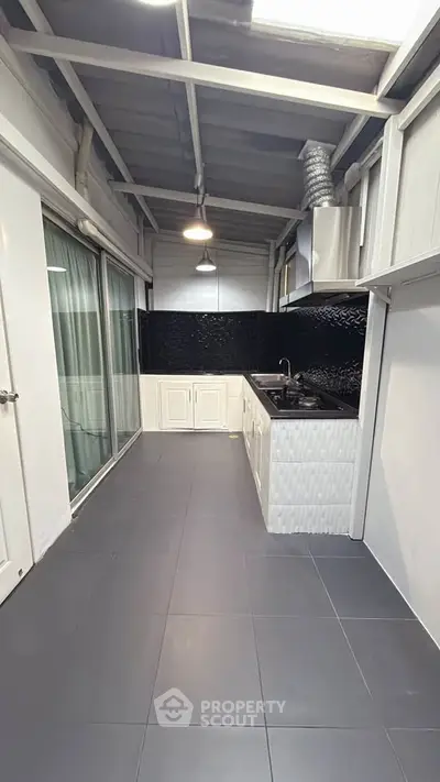 Modern kitchen with sleek black countertops and open layout design.