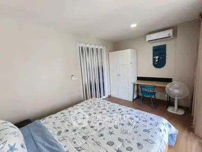 Cozy bedroom with modern decor, featuring a comfortable bed, wardrobe, desk, and air conditioning.