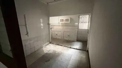 Spacious kitchen area with tiled flooring and built-in cabinets, ideal for renovation.