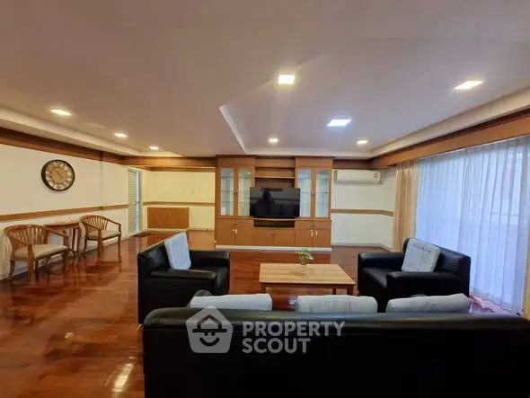 Spacious living room with elegant wooden flooring and modern furniture, perfect for relaxation and entertainment.