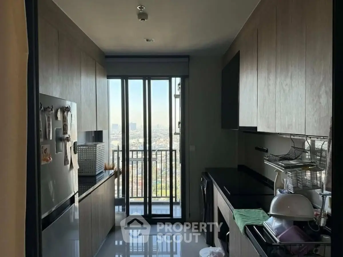 Modern kitchen with sleek cabinetry and stunning city view from balcony.