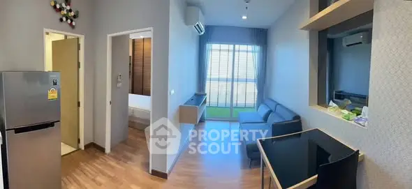 Modern living room with sleek design, featuring a cozy sofa, air conditioning, and a view of the balcony.