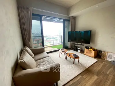 Modern living room with balcony view, cozy sofa, and large TV setup.