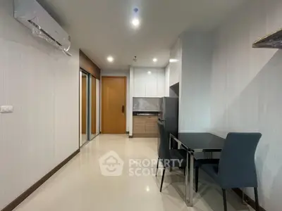 Modern apartment interior with sleek kitchen and dining area, featuring glossy floors and contemporary furniture.