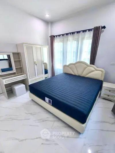 Spacious bedroom with elegant furniture and natural light