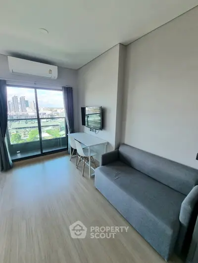 Modern living room with balcony view, featuring sleek furniture and natural light.