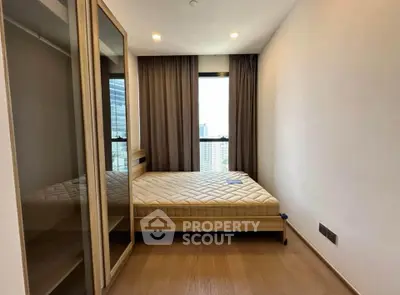 Modern bedroom with large window and wooden flooring in high-rise apartment