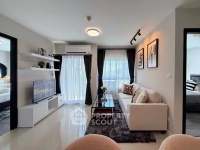 Modern living room with elegant decor, featuring a cozy sofa, stylish coffee table, and large windows for natural light.