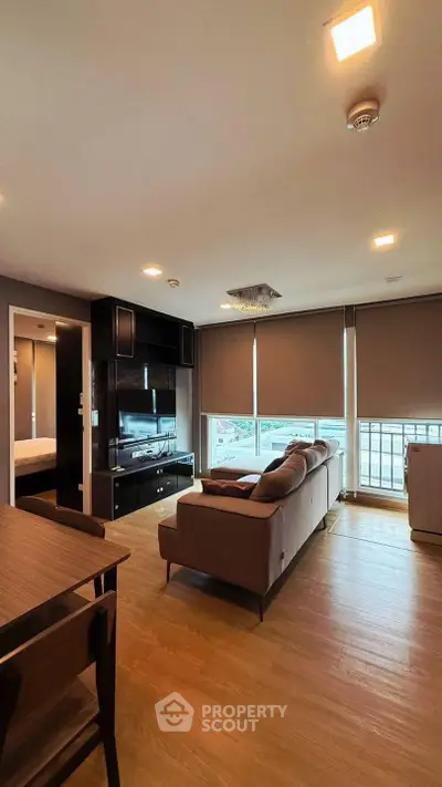Modern living room with large windows and stylish furniture in a high-rise apartment.