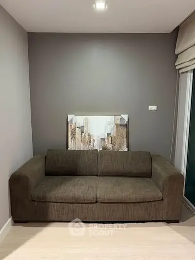 Cozy living room with modern sofa and cityscape artwork, perfect for urban living.