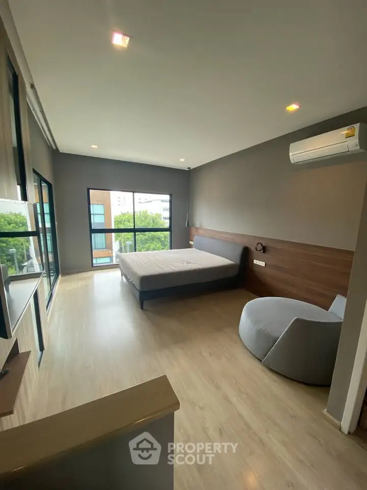 Spacious modern bedroom with large windows and stylish decor