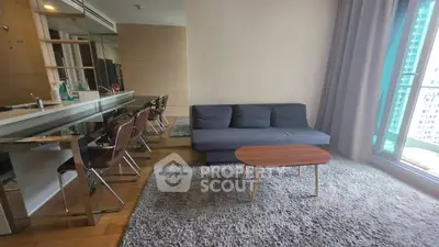 Modern living room with cozy gray sofa and stylish dining area in open layout apartment.