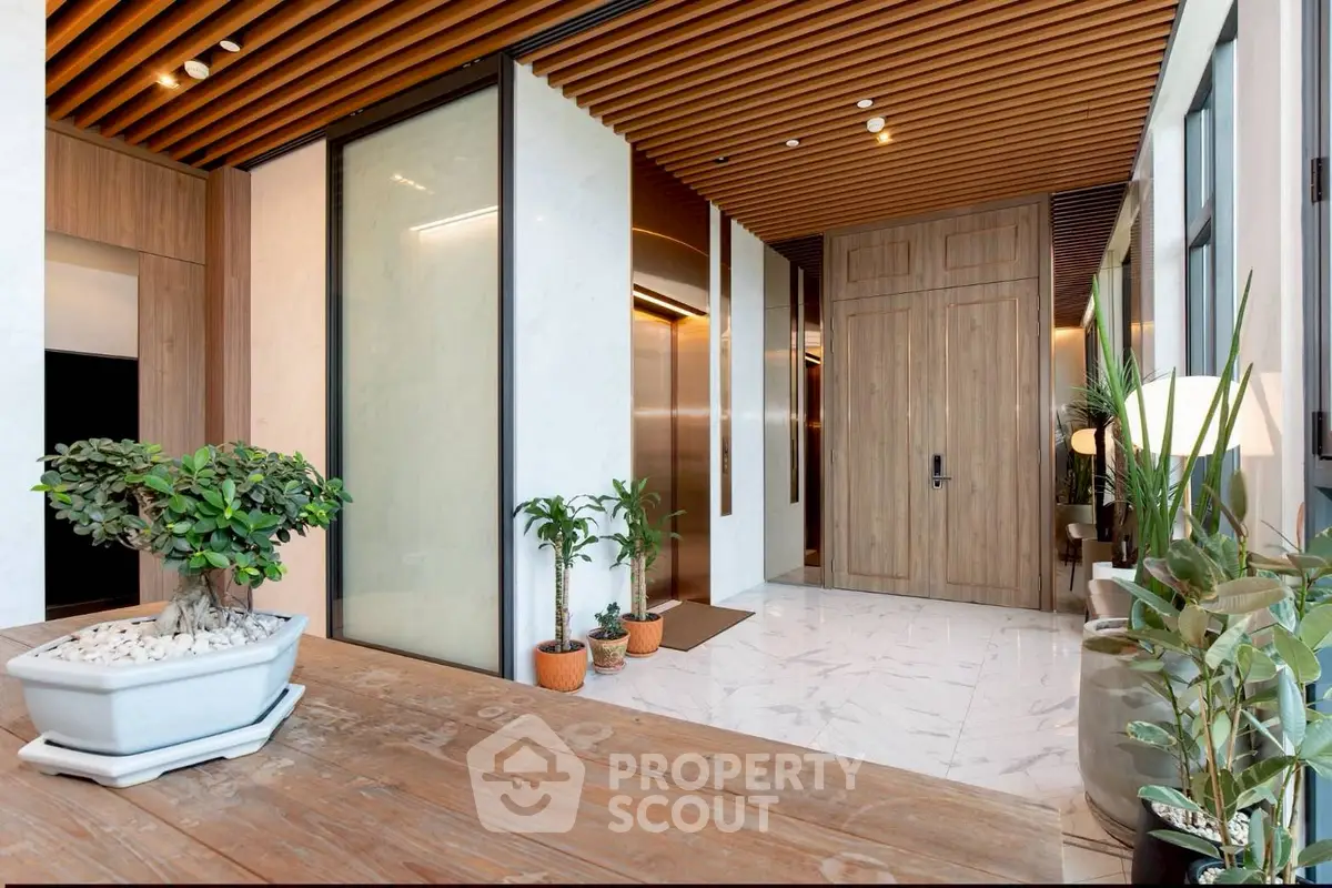 Luxurious modern lobby with elegant wooden accents and lush greenery.