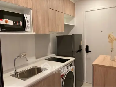 Modern compact kitchen with sleek appliances and wooden cabinetry