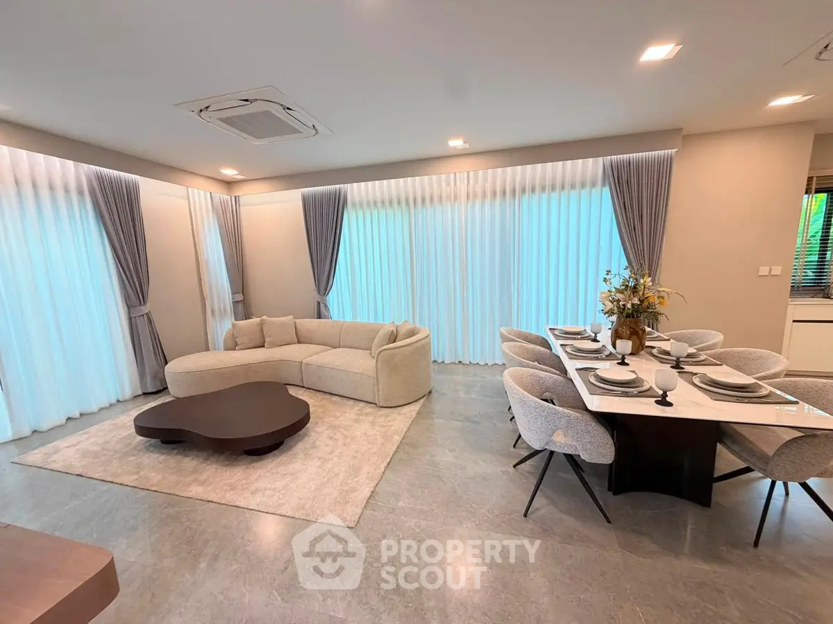 Luxurious modern living room with elegant dining area, featuring plush seating and stylish decor.