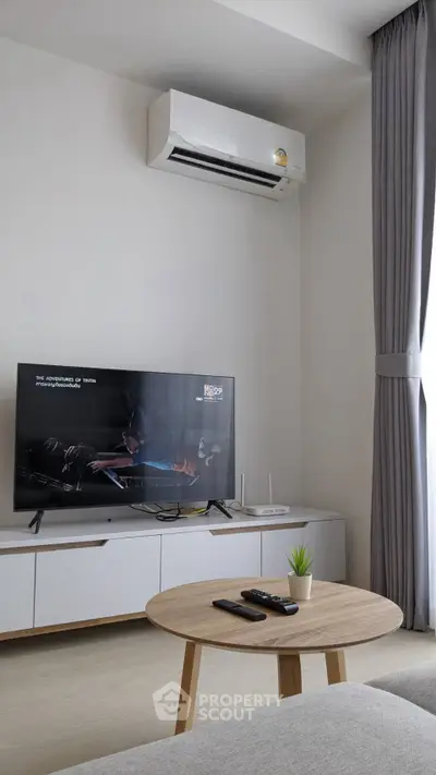 Modern living room with sleek TV setup and air conditioning, perfect for relaxation.