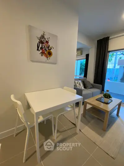 Cozy living room with modern decor and dining area in a stylish apartment.