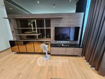 Modern living room with sleek wooden entertainment unit and large TV, featuring elegant floor-to-ceiling curtains.