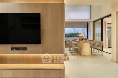 Modern open-plan living and dining area with sleek wooden finishes and large windows.