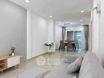 Modern living room with sleek furniture and dining area, perfect for urban living.