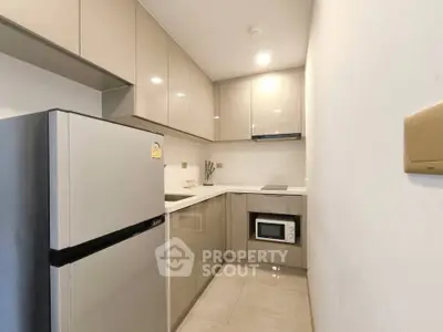 Modern kitchen with sleek cabinetry and built-in appliances in a compact layout.