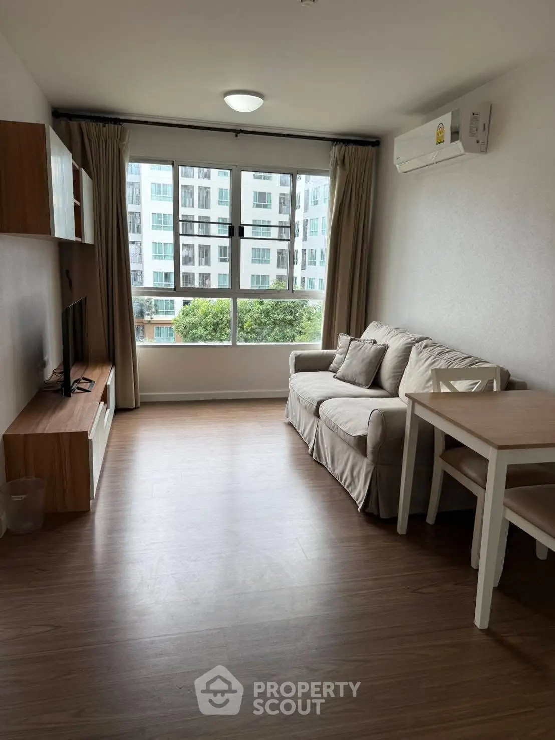 Modern living room with cozy sofa and large window view in urban apartment