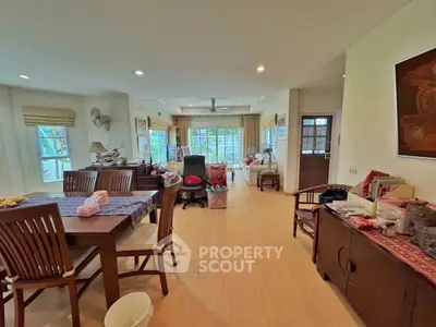 Spacious living room with wooden furniture and large windows offering natural light.