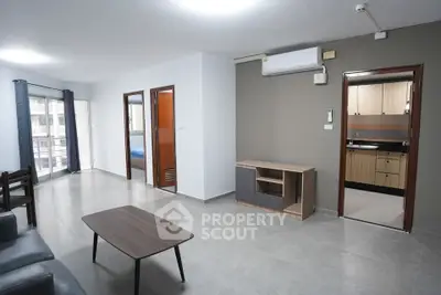 Spacious modern living room with open kitchen and balcony access