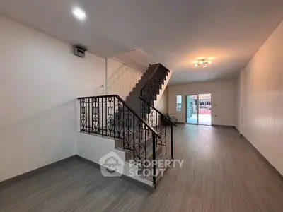 Spacious modern living room with elegant staircase and ample natural light.