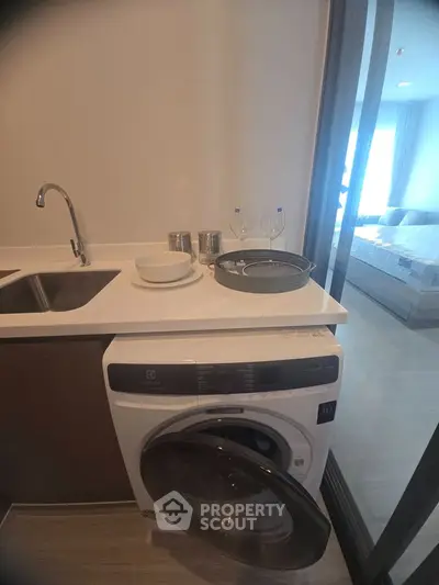 Modern kitchen with washing machine and sleek countertop in stylish apartment