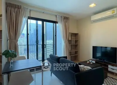Modern living room with city view, featuring sleek furniture and large windows for natural light.