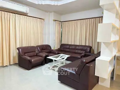 Spacious living room with leather sofas and elegant curtains