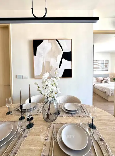 Elegant dining area with modern decor and view into cozy bedroom