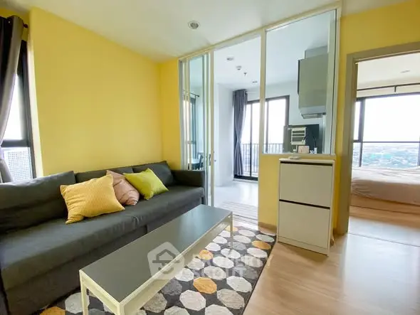 Modern living room with vibrant yellow walls and cozy furnishings in a high-rise apartment.