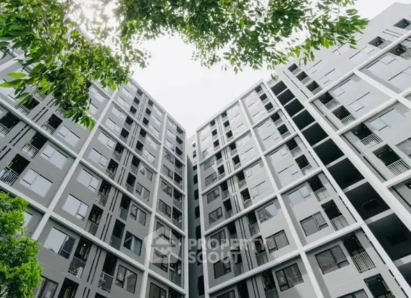 Modern high-rise apartment building with sleek design and lush greenery