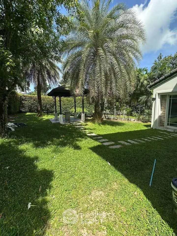 Spacious garden with lush greenery and a charming gazebo, perfect for outdoor relaxation and entertainment.