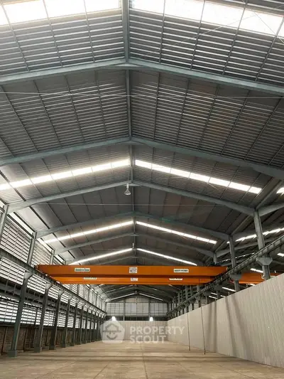 Spacious industrial warehouse with high ceilings and ample natural light, perfect for storage or manufacturing.