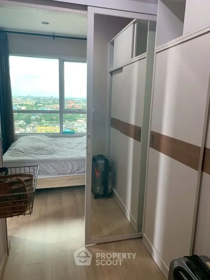 Modern bedroom with city view, mirrored wardrobe, and stylish decor in high-rise apartment.
