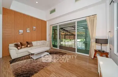 Spacious living room with modern decor and large sliding glass doors opening to balcony.